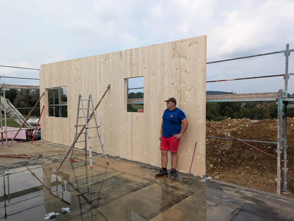 Vorgefertigte Holzwand wird auf der Baustelle aufgerichtet